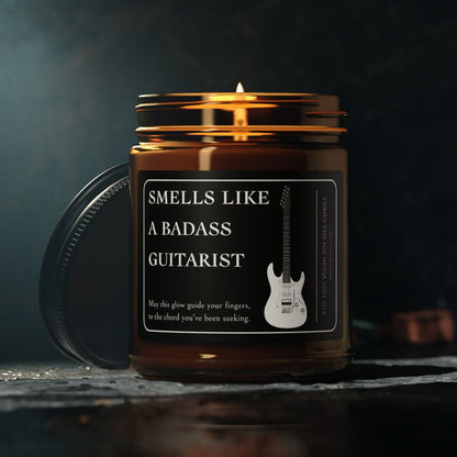 Candle in a jar with a label reading 'Smells like a badass guitarist' on a dark background