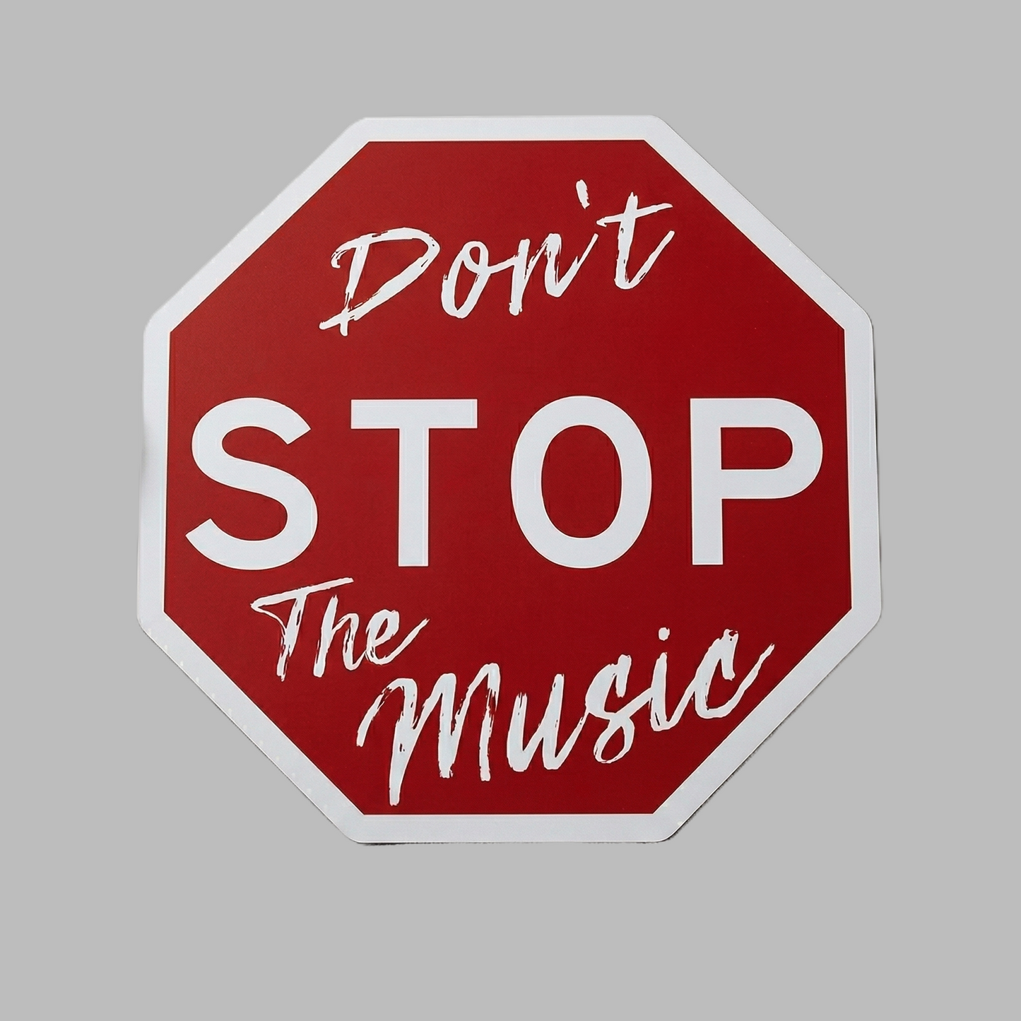 Red stop sign with 'Don't Stop The Music' text on a gray background